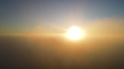 sunrise sun rays in foggy hazy clouds - aerial helicopter view