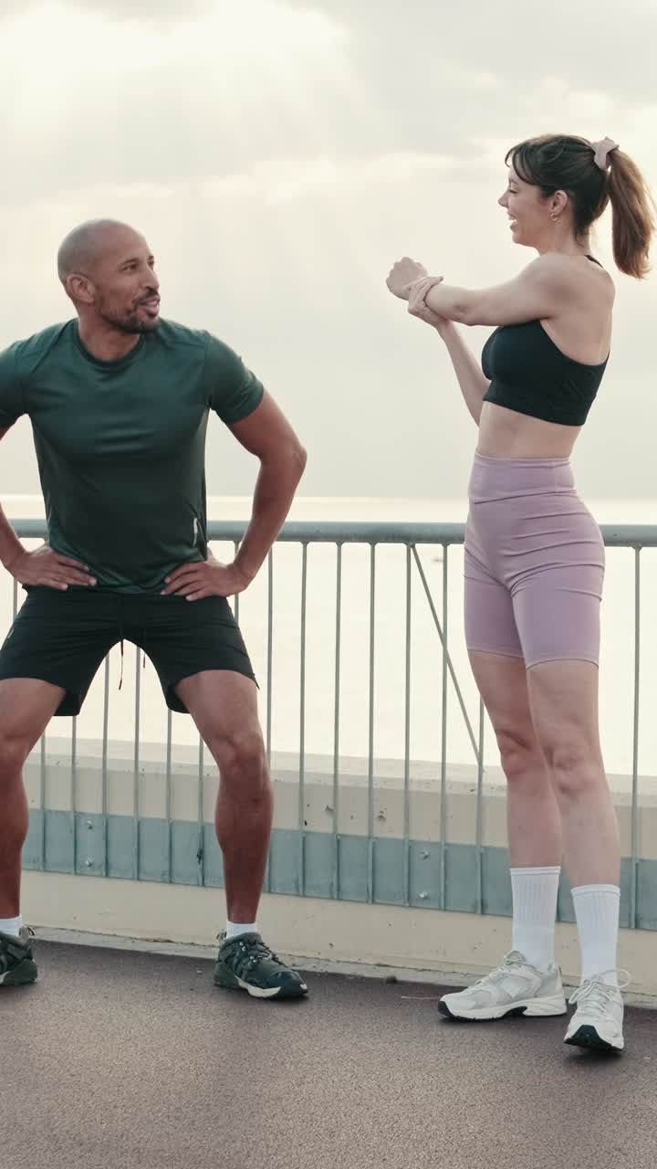 Man and Woman Stretching and Warming Up Outdoors by the Sea