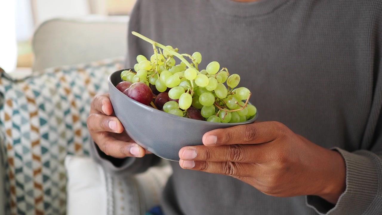 Pessoa segurando uma tigela de uvas frescas