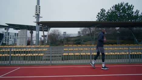 man running on a track in a stadium