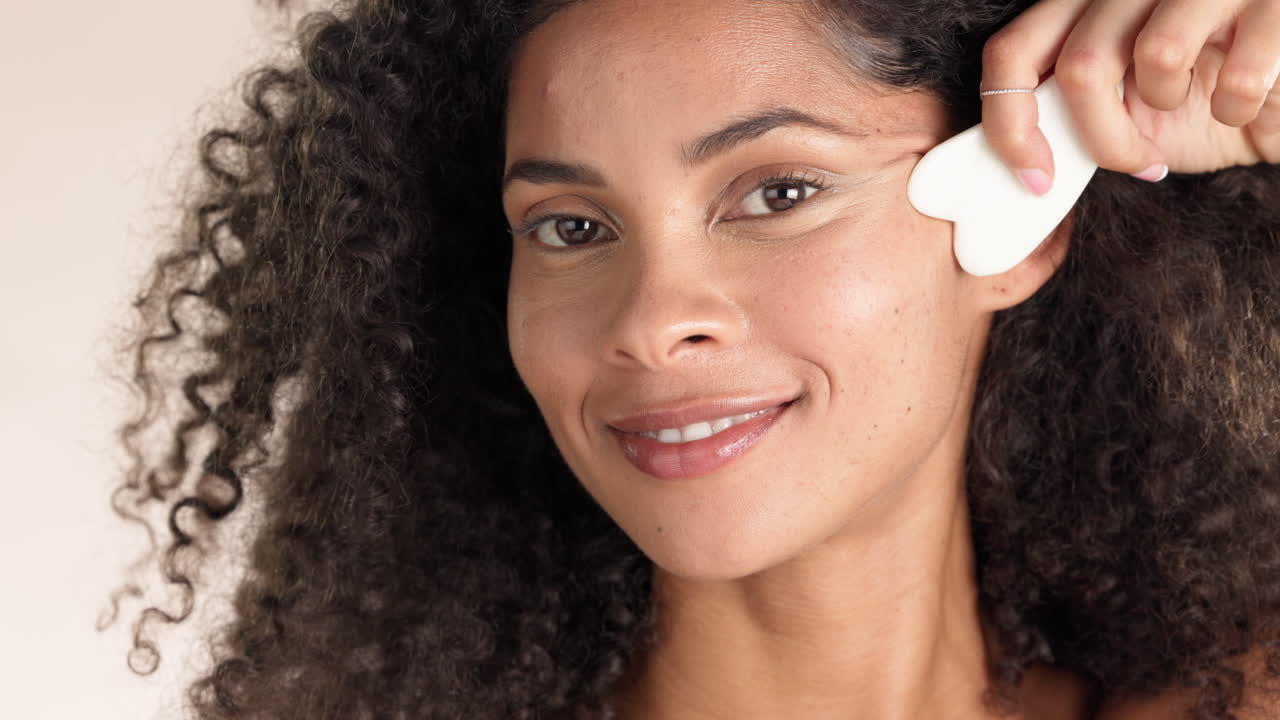 Face, gua sha and black woman in studio