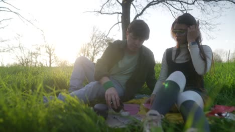 couple playing cards in a park at sunset