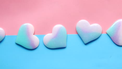 pastel iridescent hearts on a pink and blue background