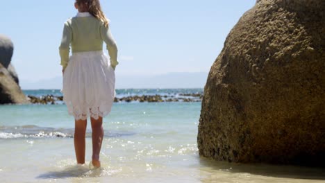chica caminando sobre el agua en la playa 4k