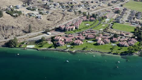 drone flying over houses towards lake and mountains