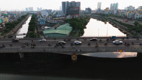 a breathtaking aerial shot captures a bustling city bridge bathed in the warm glow of the setting sun. vehicles of all shapes and sizes flow smoothly across the bridge