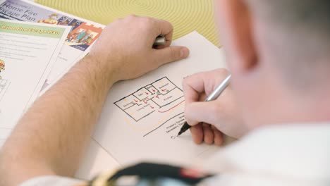 fire prevention officer creating a home escape plan on paper