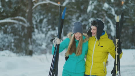 Aktives-älteres-Paar-Auf-Skiern,-Das-Sich-Während-Des-Trainings-Im-Winterwald-Im-Schneefall-Die-Schneeverwehung-Hinunterbewegt