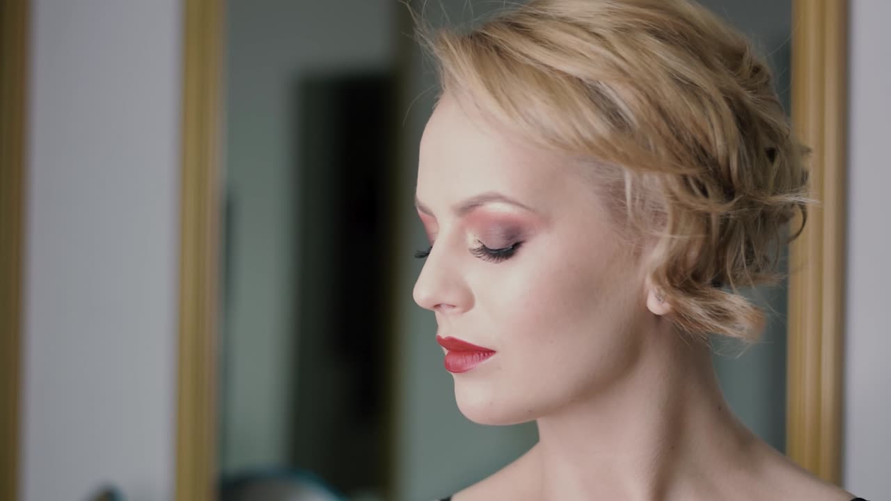 красивая модель-блондинка со свежим макияжем смотрит вдаль, затем в камеру, демонстрируя свои потрясающие глаза