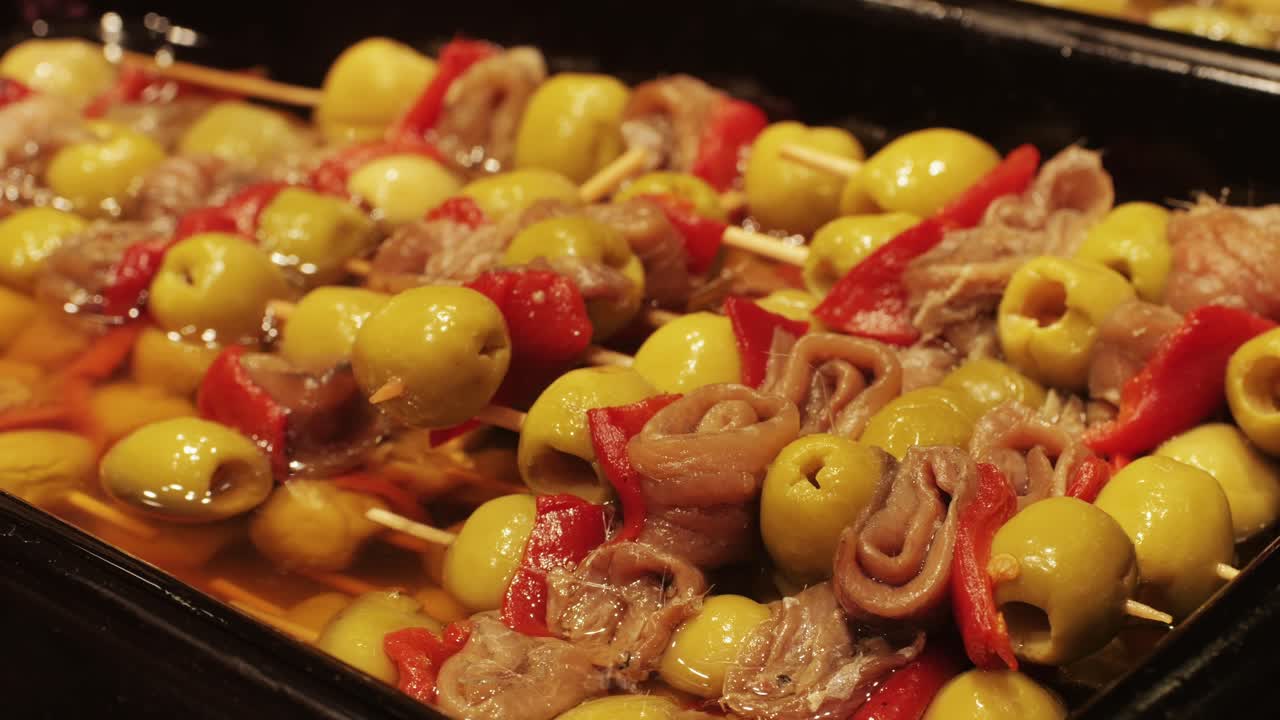 Marinated green olives in spicy sauce, spanish traditional food, ideal for Mediterranean dish or snack, market in barcelona.