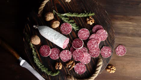 slices of salami with rosemary and walnuts slowly rotate.