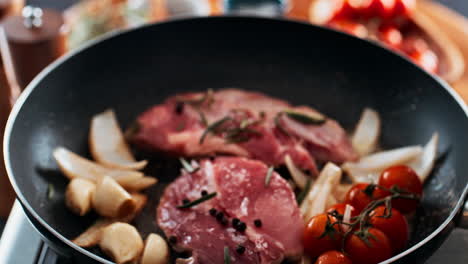 pork medallions with tomatoes, garlic, and rosemary in a pan