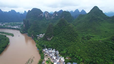 aerial panoramic views of mountainous xingping ancient town and brown li jiang river, china