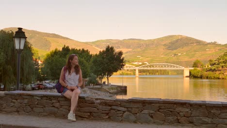 girl sitting on a bridge next to the douro river