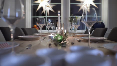 mesa decorada de navidad en casa con velas, preparación de la cena familiar, tiro de muñeca