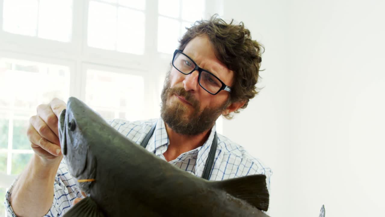 artesano trabajando en la escultura de peces 4k