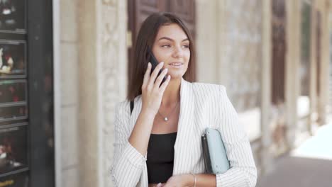 beautiful young business woman walking and talking on a smart phone