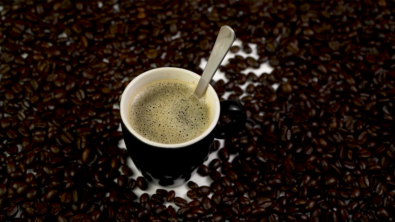 Stabil optagelse af en kop kaffe med en ske, hvor der tilsættes sukker.