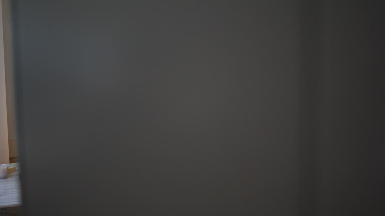 Young couple sitting closely on sofa watching television side view. Spouses home