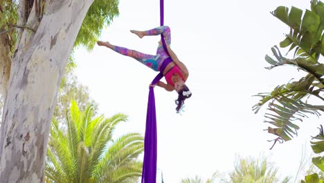 bailarina acrobática exótica trabajando en cinta de seda
