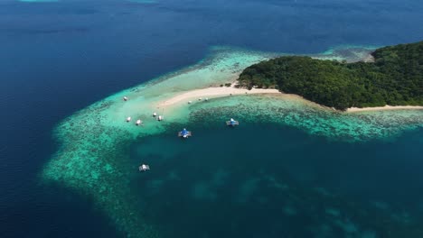una isla paradisíaca tropical con barcos y turistas.