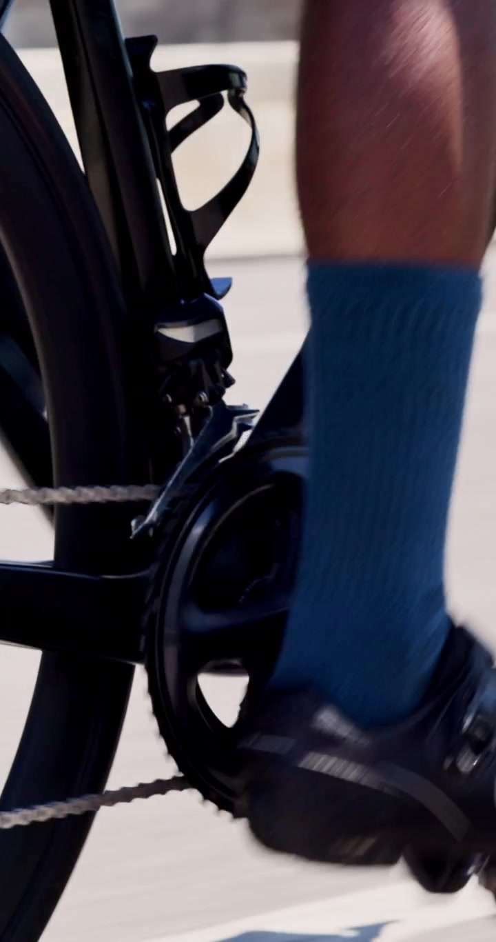 Close-up of Cyclist Pedaling Road Bike on Paved Road
