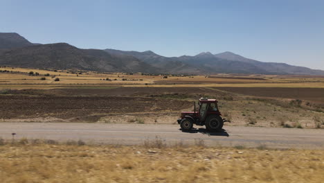 Tractor-driving-on-the-roads-by-the-farmers-fields-and-mountains