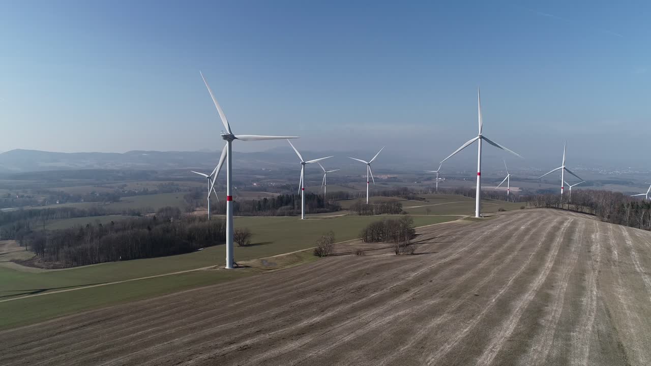 Wind mills in beautiful field creating electricity - aerial shot