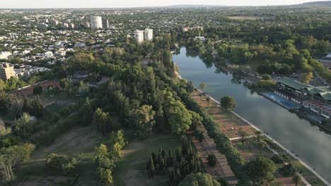 Paisaje-Urbano-Del-Parque-De-La-Ciudad-De-Mendoza,-Argentina,-Drone-Aéreo-Sobre-El-área-Verde,-Orilla-Del-Lago-Y-Arquitectura-Local-En-El-Horizonte,-Parque-General-San-Martin