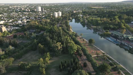 paisaje urbano del parque de la ciudad de mendoza, argentina, drone aéreo sobre el área verde, orilla del lago y arquitectura local en el horizonte, parque general san martin