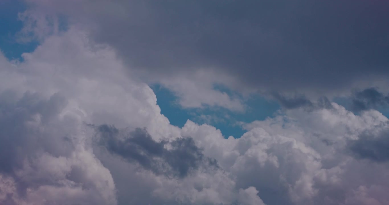 Dynamic Cloudscape with White and Grey Clouds Moving Across Blue Sky