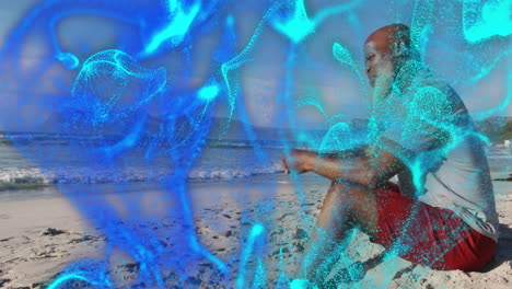 senior man sitting cross-legged on beach meditating, tech overlay showing drifting cyan particles