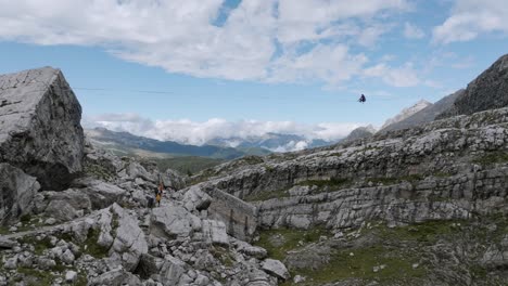 aerial forward shot showing silhouette of jumping person on slackline in rocky mountains