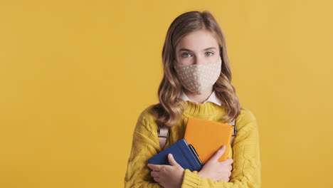 Teenage-Caucasian-girl-with-face-mask-holding-books.