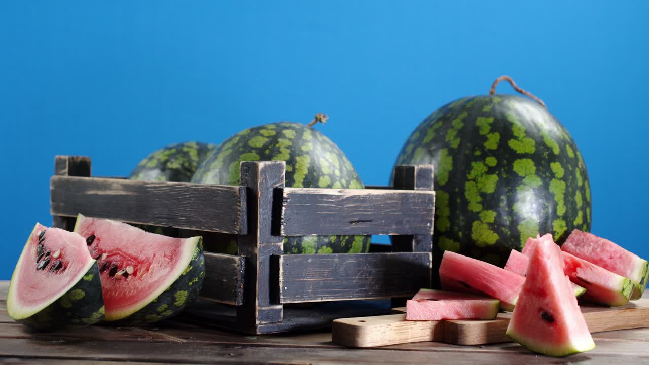 나무 상자 안의 수박 조각과 전체 수박을 천천히 회전시니다.