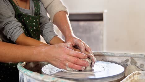female potter assisting a girl