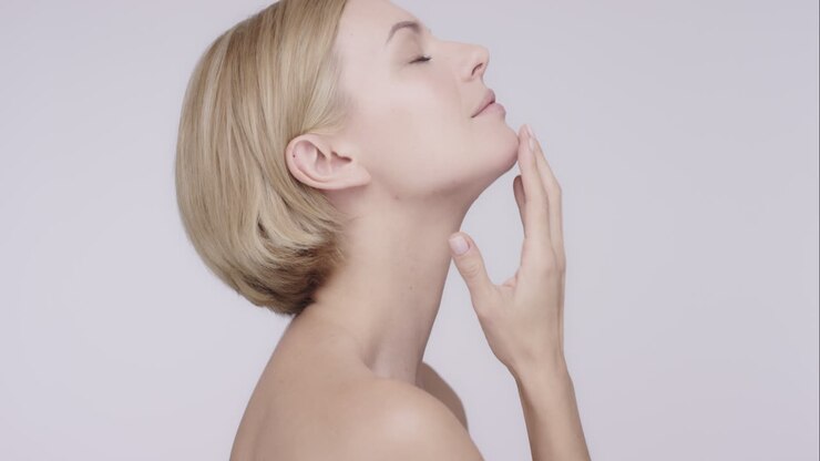 Beautiful healthy woman stroking neck touching skin in slow motion for beauty skincare concept on a grey background Red Epic Dragon