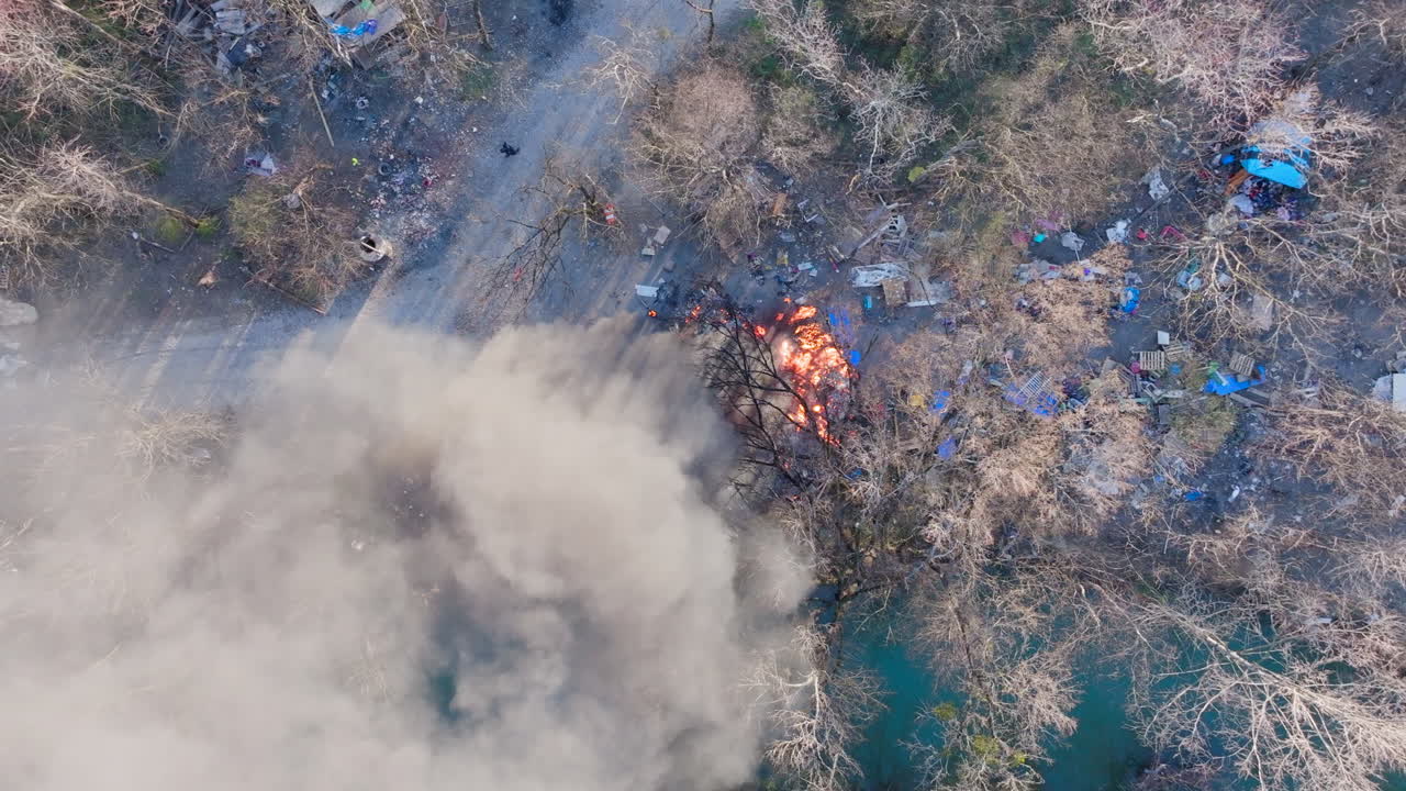 Top down aerial drone footage of a fire in a forest that starts to rotate.