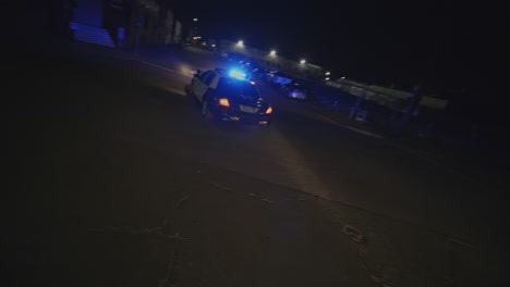 cinematic slow motion shot of two police cars pulling over a car at nighttime