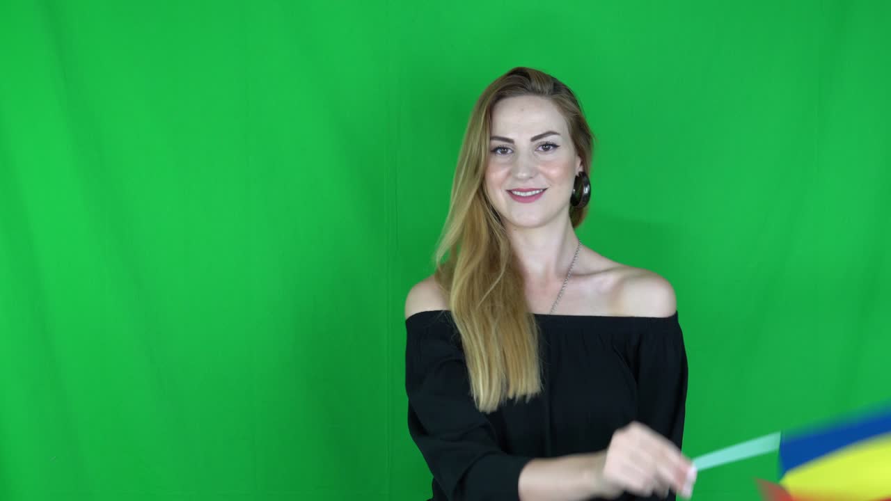 mujer rubia agitando delante de la bandera rumana pantalla verde, fondo clave de croma