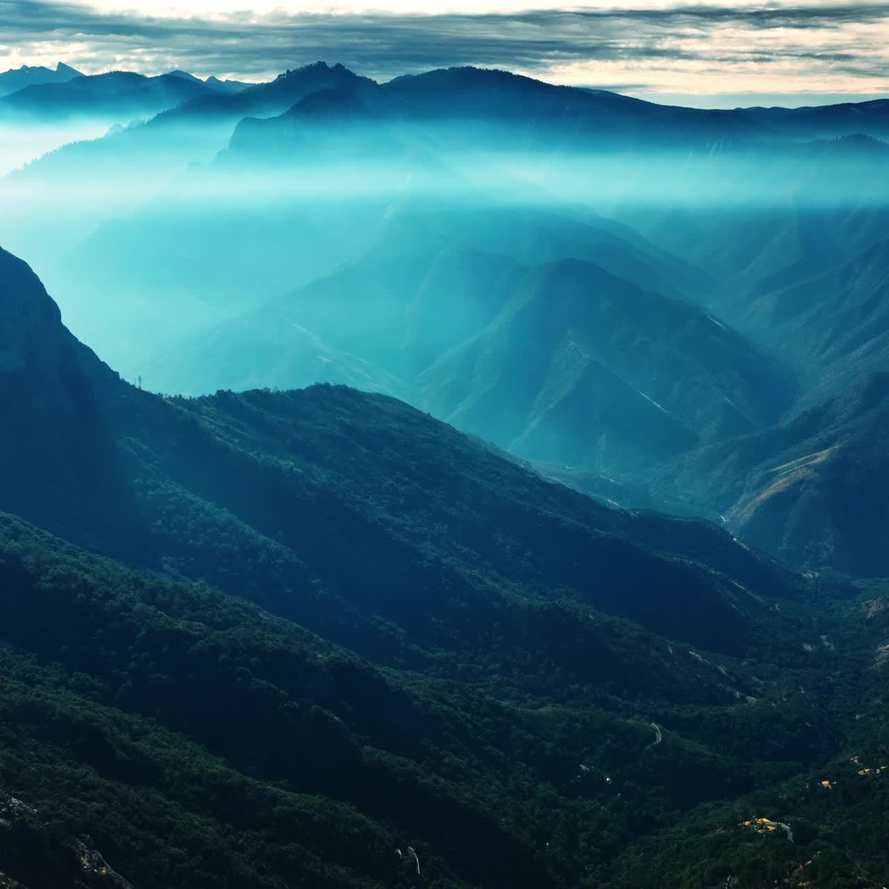 Gorgeous mountains in blue mist. Amazing view of the mountain range in California overgrown with greenery. Top view