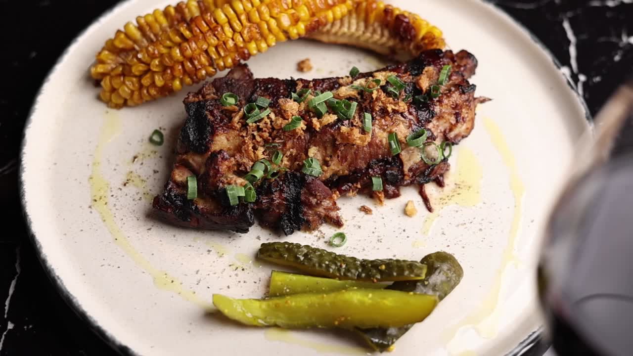 costillas de cerdo a la parrilla con maíz y pepinillos