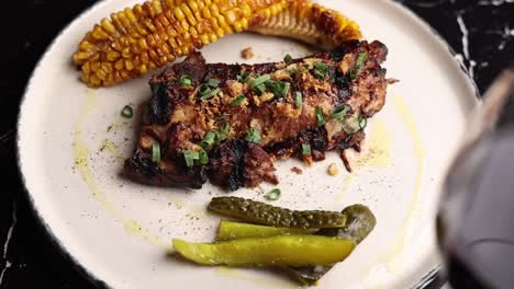 costillas de cerdo a la parrilla con maíz y pepinillos