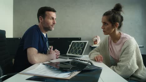 caucasian female patient listening to diagnosis of mri scan from male caucasian doctor