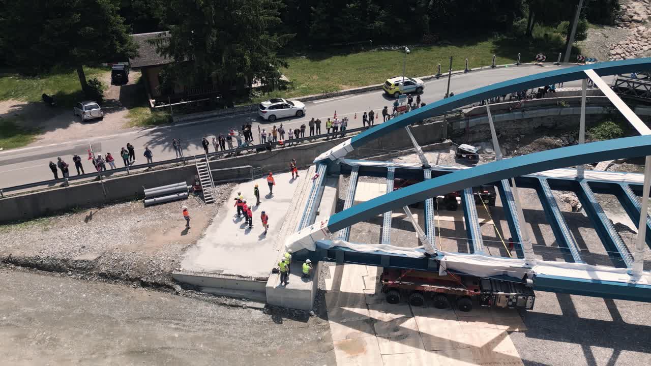 Bridge Construction: Aerial View of a Steel Arch Bridge Being Lifted into Place