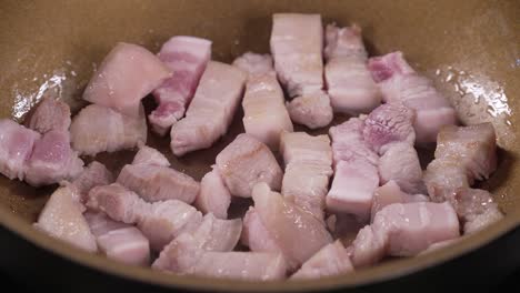 panceta de cerdo rosa cruda frita en sartén, carne de cerdo cortada en tres capas, colesterol, grasas saturadas, riesgos para la salud de una dieta poco saludable, precio de la carne de cerdo