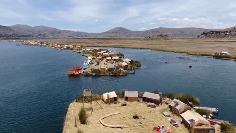 drone aerial view in peru flying over huros settlements in small islands with small boats and manmade houses in the titikaka lake in puno on a sunny day