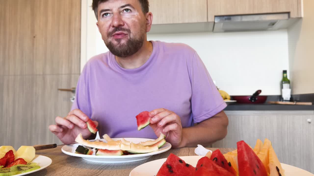 Man eating fruit in the kitchen