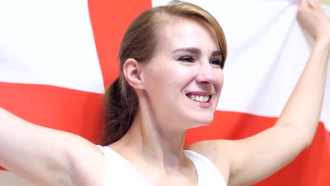una joven inglesa celebra sosteniendo la bandera de inglaterra en cámara lenta