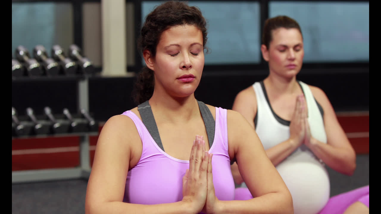 Donne incinte che fanno yoga in uno studio fitness